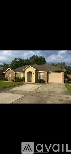 A house with a brown roof and a driveway in front.
