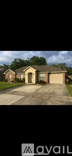 A house with a brown roof and a driveway in front.