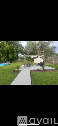 A backyard with a white fence and a small shed.