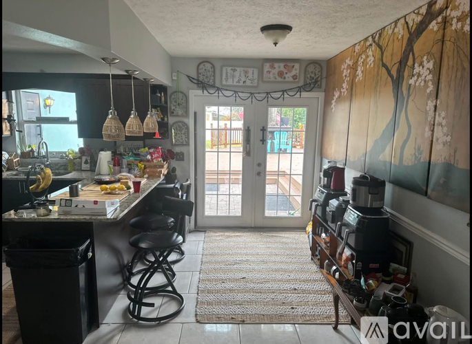A kitchen with a bar stool and a counter with food on it.