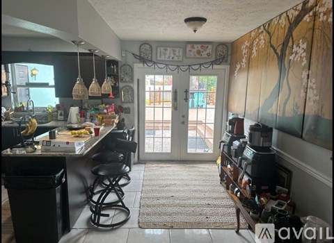 A kitchen with a bar stool and a counter with food on it.
