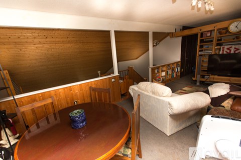 A living room with a wooden table and a couch.