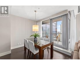 A dining room with a table and chairs and a window with a view of the city.