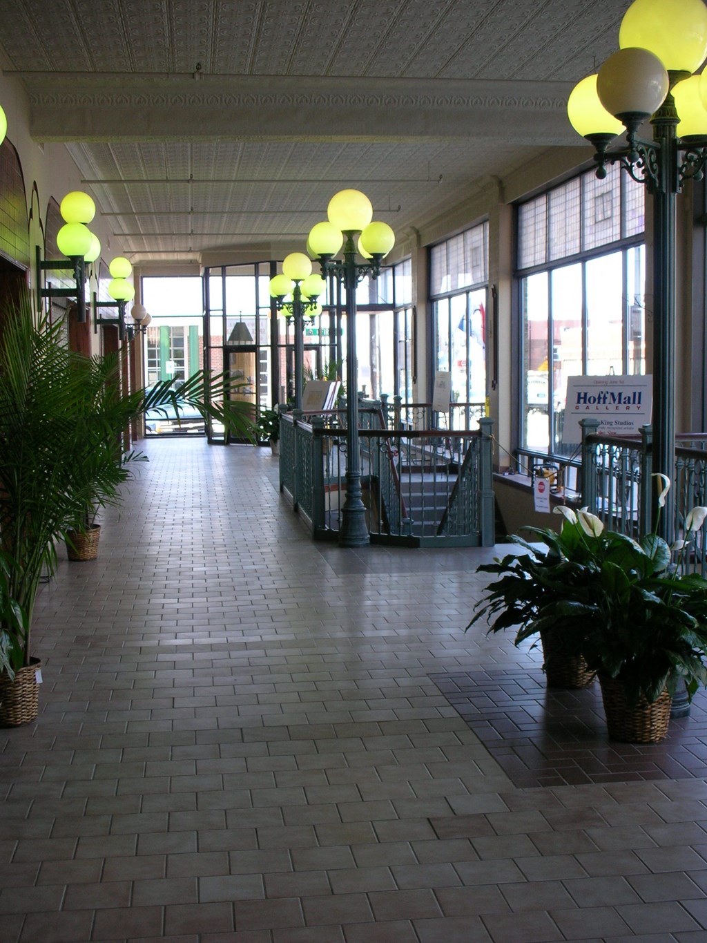 the lobby of a building with potted plants and large windows