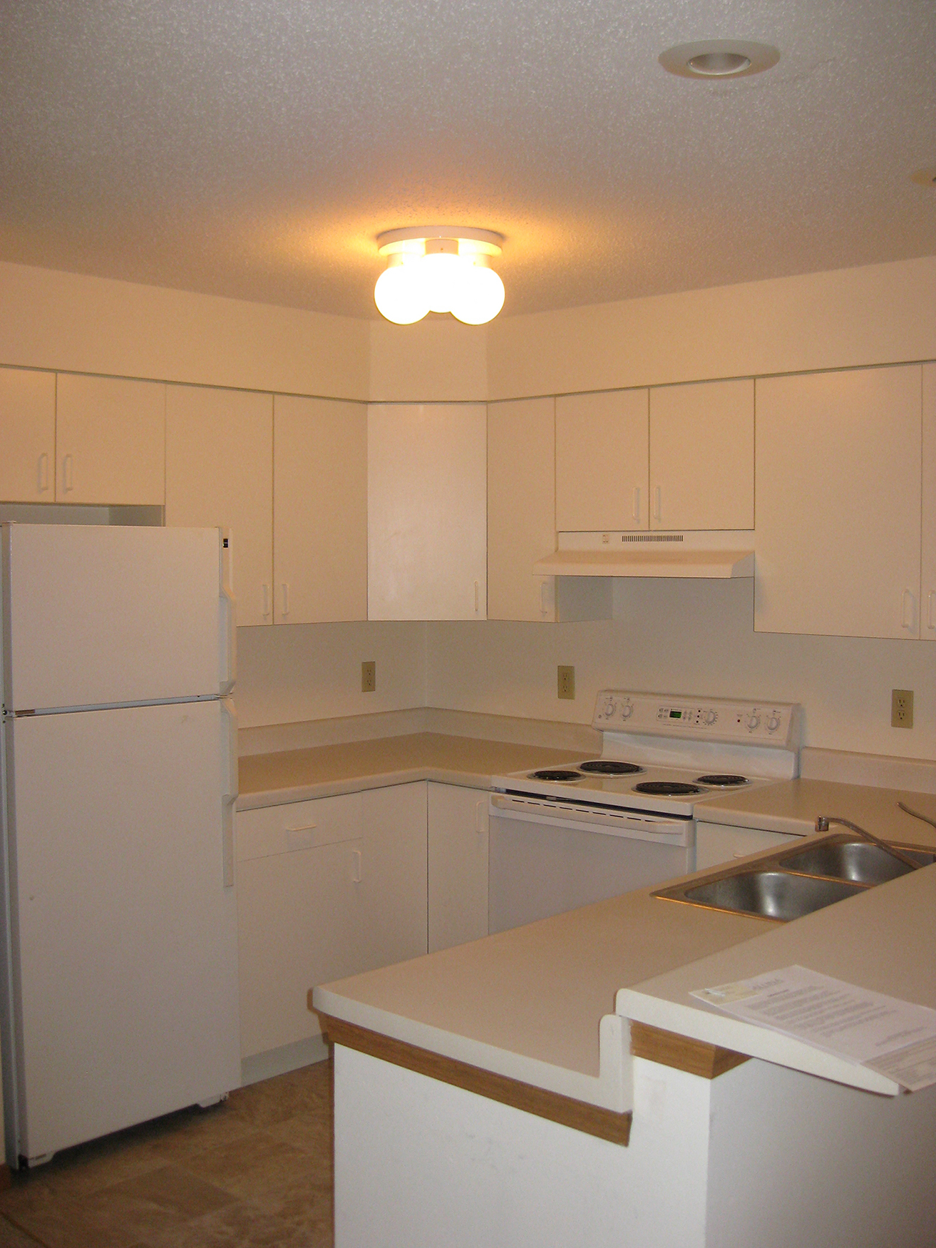 a kitchen with white cabinets and appliances and a white refrigerator