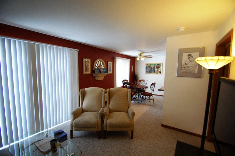 the living room and dining room of a home with a couch and chairs