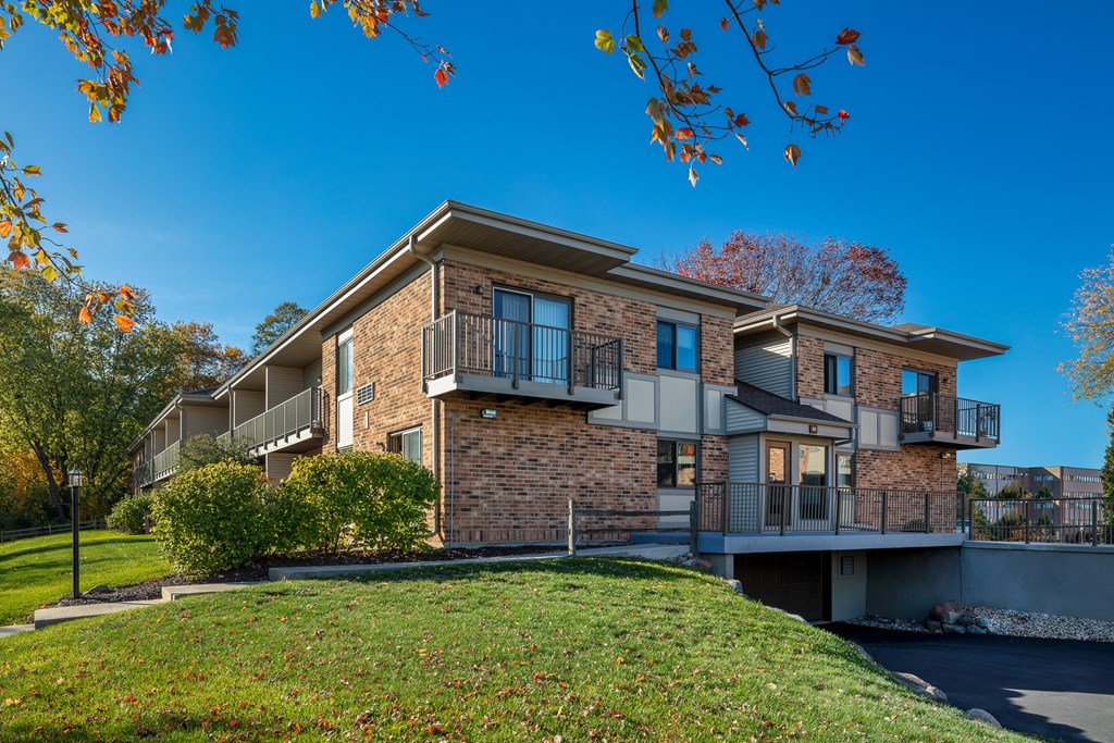 a brick apartment building with balconies on the side of a hill