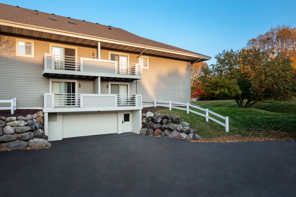 a house with a white railing on the side of a driveway
