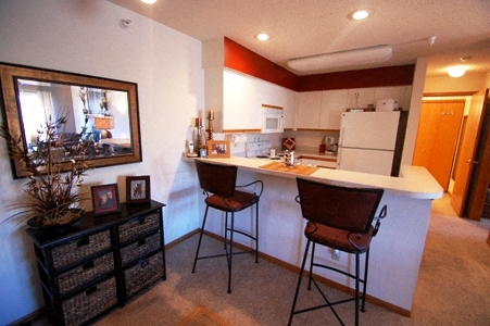 a kitchen with a bar with two chairs