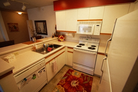 a kitchen with white appliances and a sink and a refrigerator