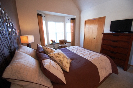 a bedroom with a large bed and a tv