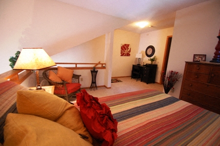 a bedroom with a bed and a couch and a dresser