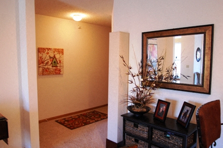 a living room with a mirror and a dresser