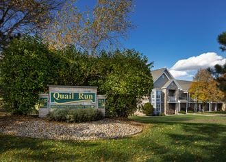 the quail run sign in front of a house