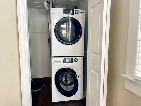 A white front load washing machine in a small laundry room.