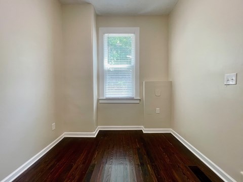 A room with wooden floors and a window.