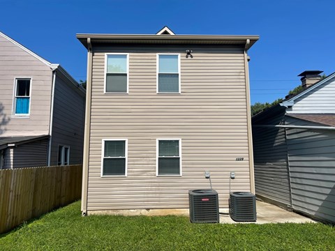 A house with two air conditioning units in front.