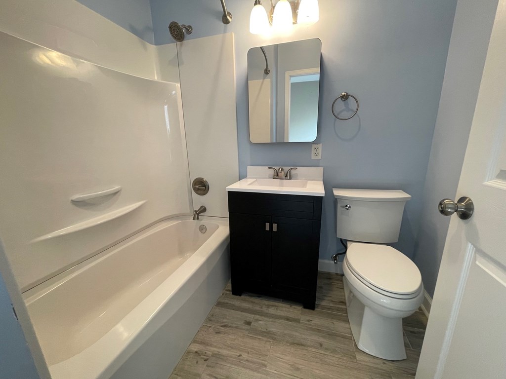 A white toilet sits next to a sink in a bathroom.