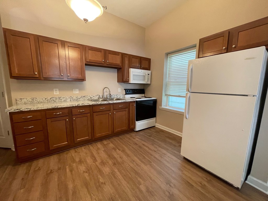 A kitchen with wooden cabinets and a white refrigerator.