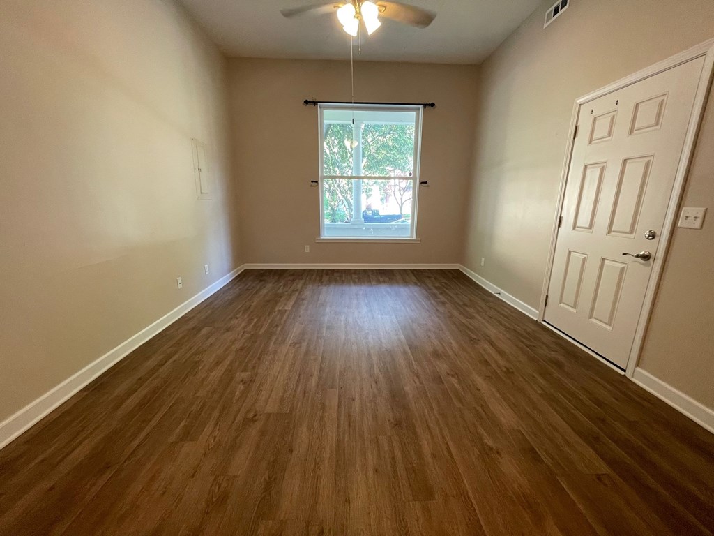 A room with wooden flooring and a white door.