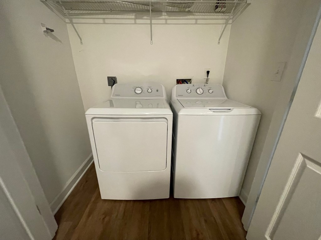 Two white front loading washing machines in a small laundry room.