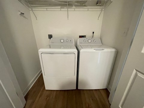 Two white front loading washing machines in a small laundry room.