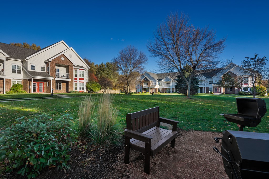 a park bench in front of a yard with houses