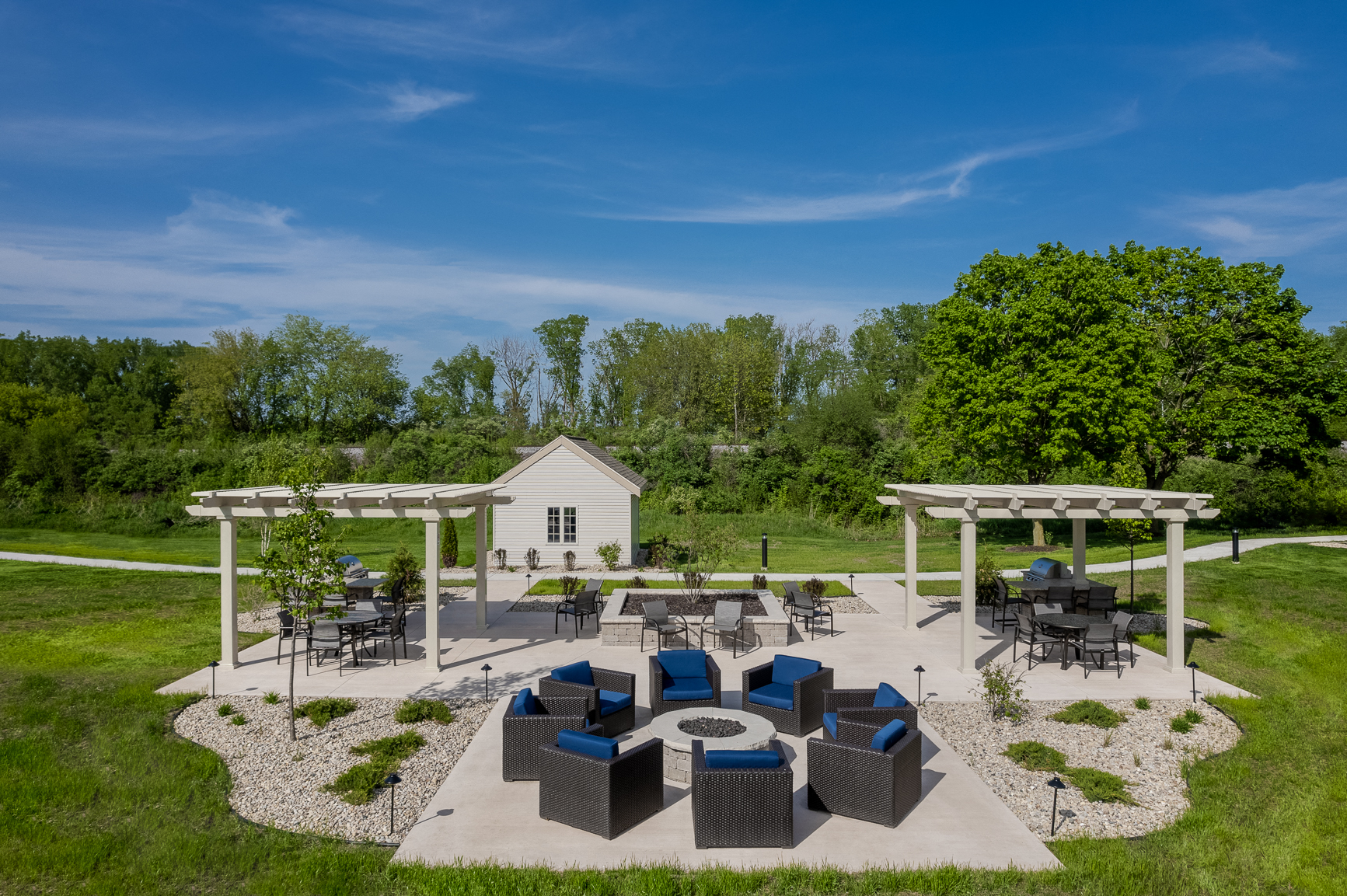 a patio with couches and tables and a fire pit