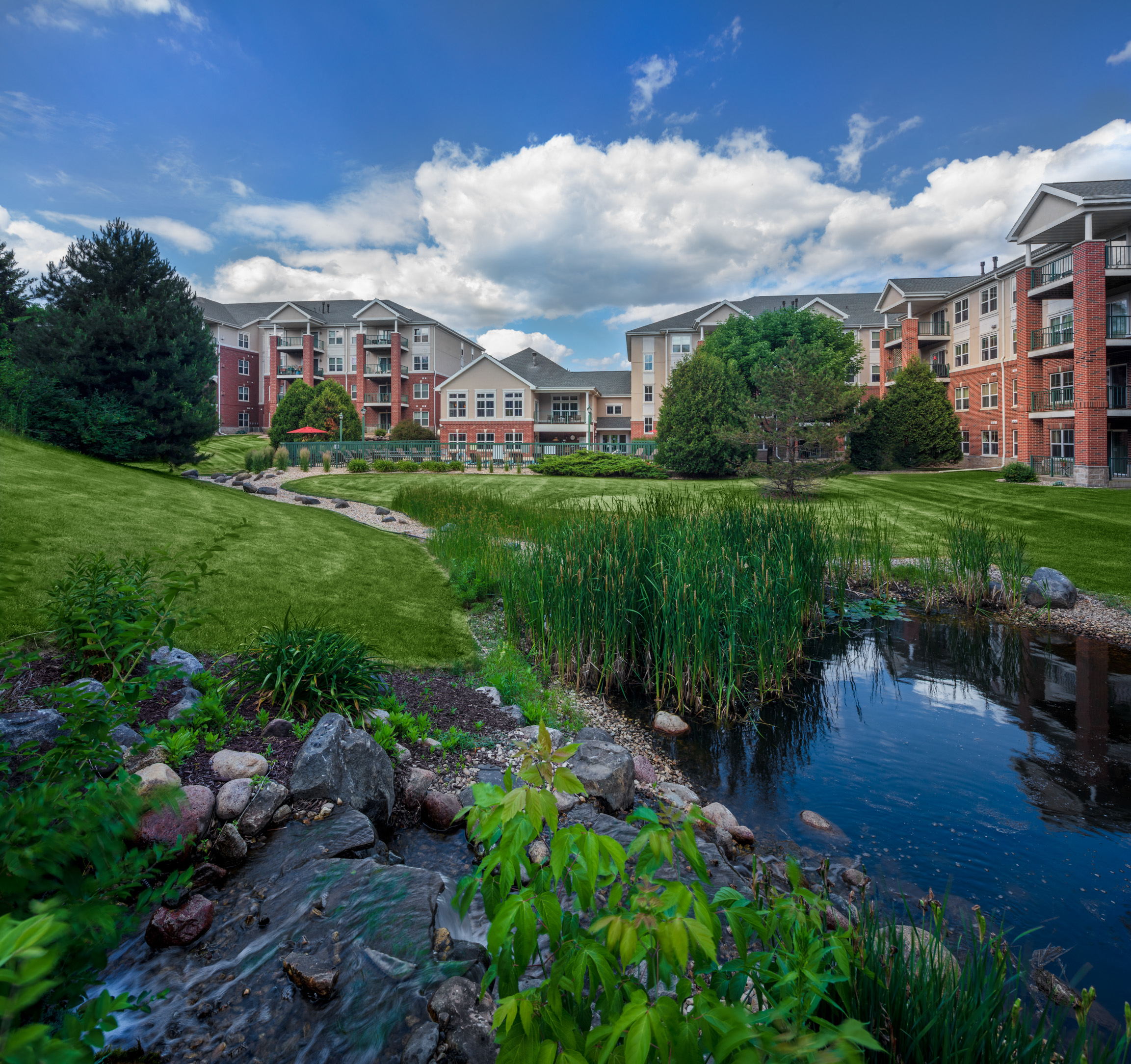 an urban park with a pond in front of an apartment building