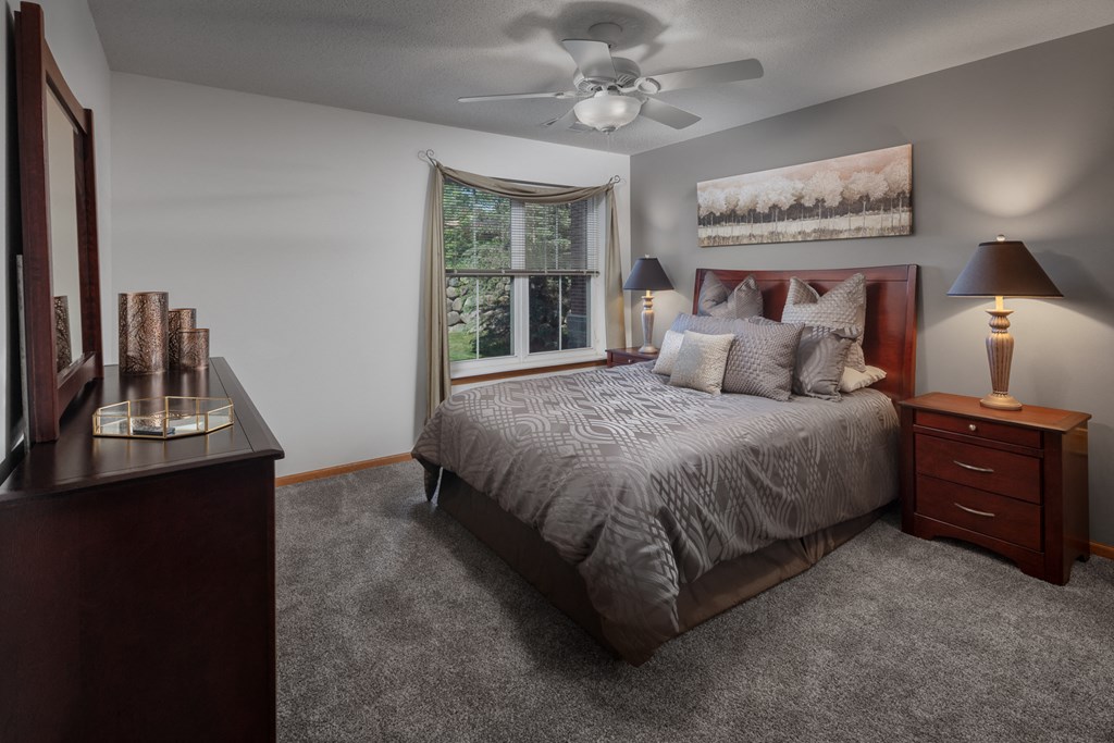 a bedroom with a large bed and a ceiling fan