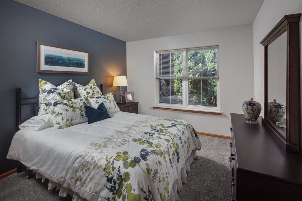 a bedroom with a bed and a dresser and a window