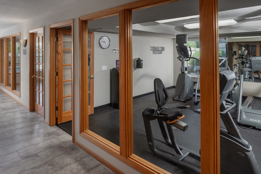 a gym with exercise equipment and mirrors on the wall