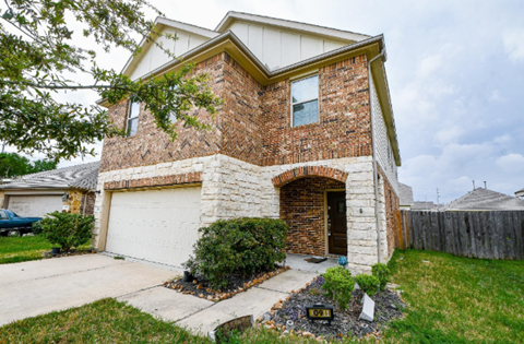 A house with a white garage door and a brick chimney.