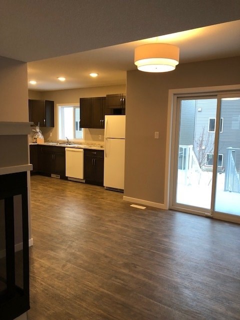 A kitchen with a white refrigerator and black cabinets.