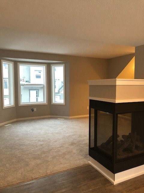 A living room with a fireplace and carpeted floor.