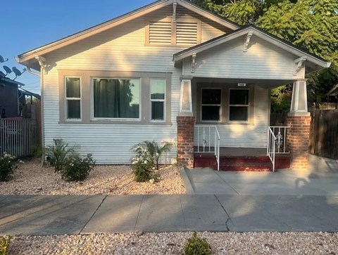 A small house with a porch and a garage door.
