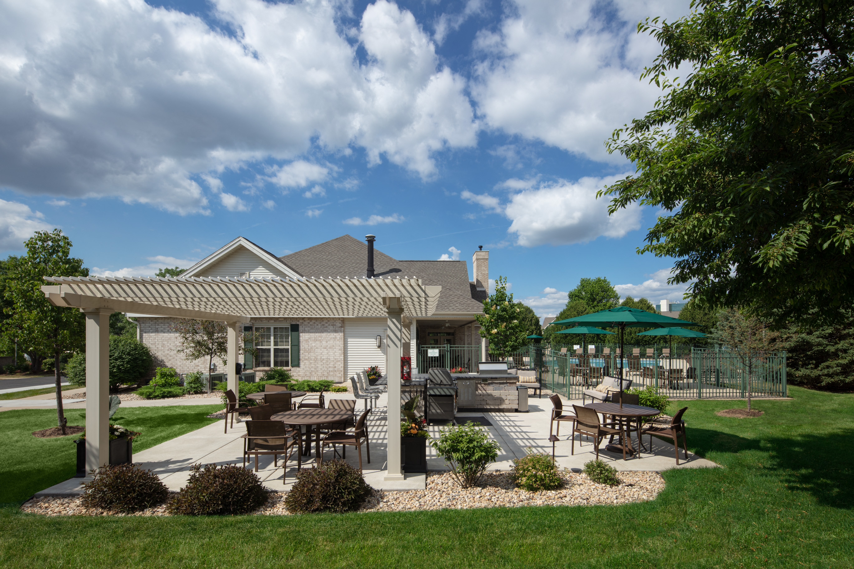 a patio with tables and chairs in front of a house