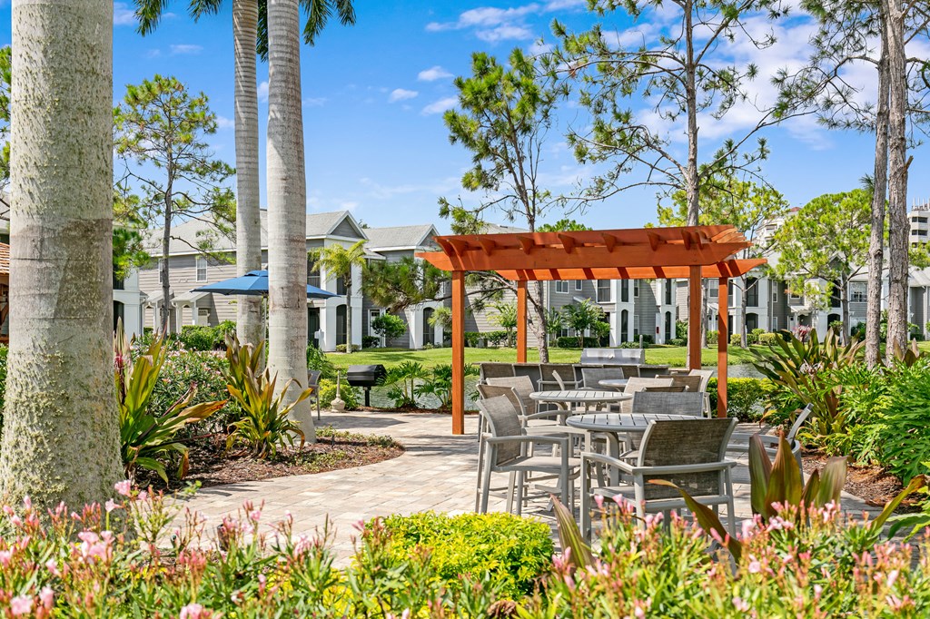 a patio with tables and chairs and trees