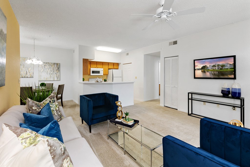 a living room with blue couches and a glass table