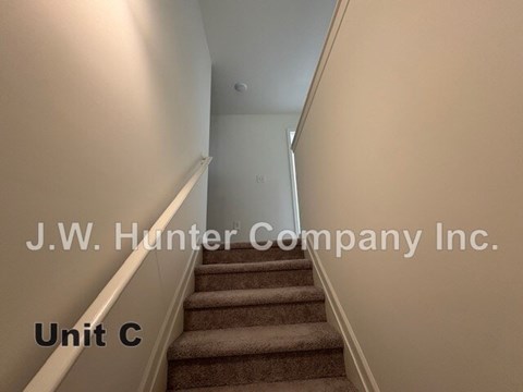 A staircase in a building with the text "J.W. Hunter Company Inc. Unit C" displayed.