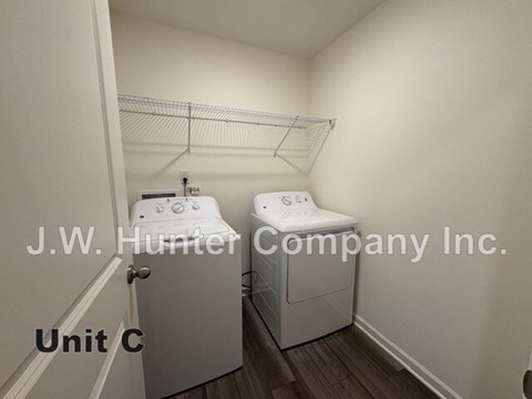 A laundry room with two washing machines and a sign that says J.W. Hunter Company Inc.