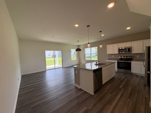 A kitchen with a large island and wooden floors.