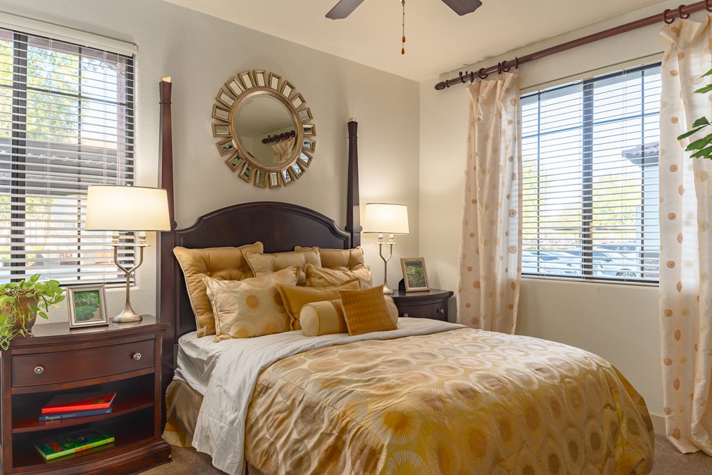 a bedroom with a large bed and two windows