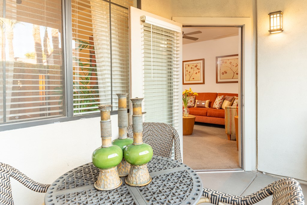 a patio with a table and chairs and a couch in the background