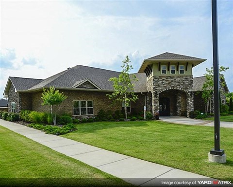 a brick house with a lawn and a sidewalk