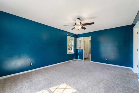 A room with blue walls and a ceiling fan.