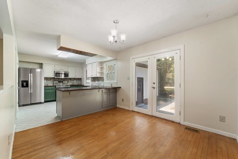 A kitchen with white cabinets and a stainless steel island.