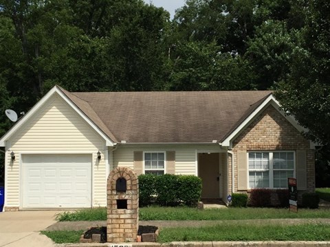 A house with a white garage door and a brown roof.
