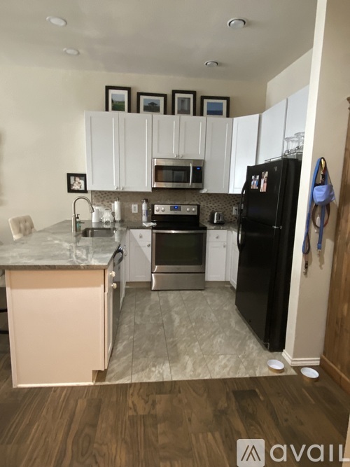A kitchen with black appliances and white cabinets.