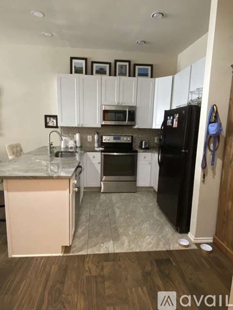 A kitchen with black appliances and white cabinets.